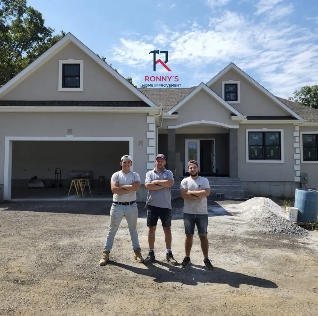 The Ronny’s Home Improvement team in front of a newly built home